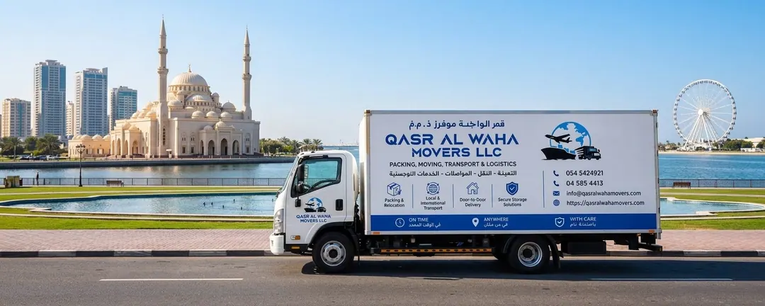 A Qasr Al Waha Movers truck beside the lagoon in Sharjah, with a mosque and the observation wheel behind