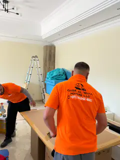 A mover lifting a large carton onto a stack
