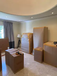 Packed cartons stacked and ready in an emptied villa room