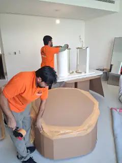 A mover wrapping table lamps individually before packing