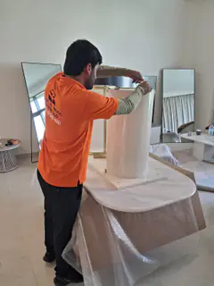 A mover protecting a round table top before it is moved