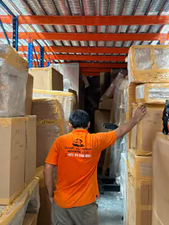 A mover checking wrapped goods stacked in the warehouse