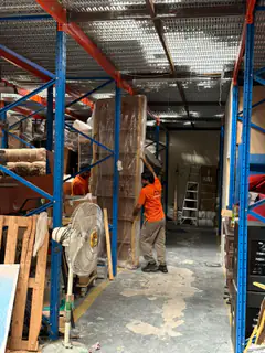 A mover moving goods along a warehouse racking aisle