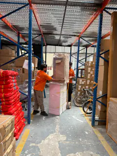 Wrapped furniture and cartons stored on warehouse racking