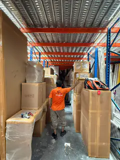 A mover among racked household goods in storage