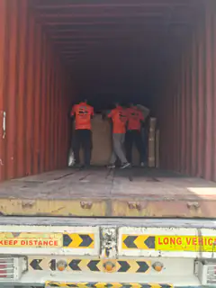 Two movers positioning goods inside a part-loaded container