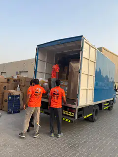 Two movers loading cartons into the back of a box truck