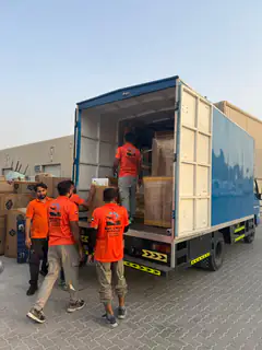 Movers stacking a load in a box truck at the warehouse