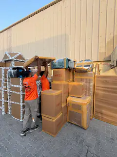 A mover beside a consignment of wrapped furniture ready to load