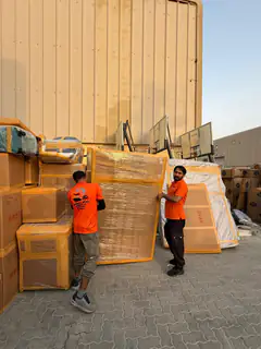 A mover moving a wrapped item past a staged consignment