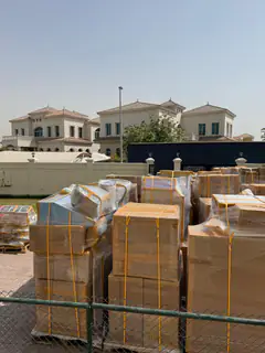 A wrapped consignment laid out for loading outside a villa