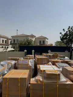A consignment of packed goods staged beside the villa wall